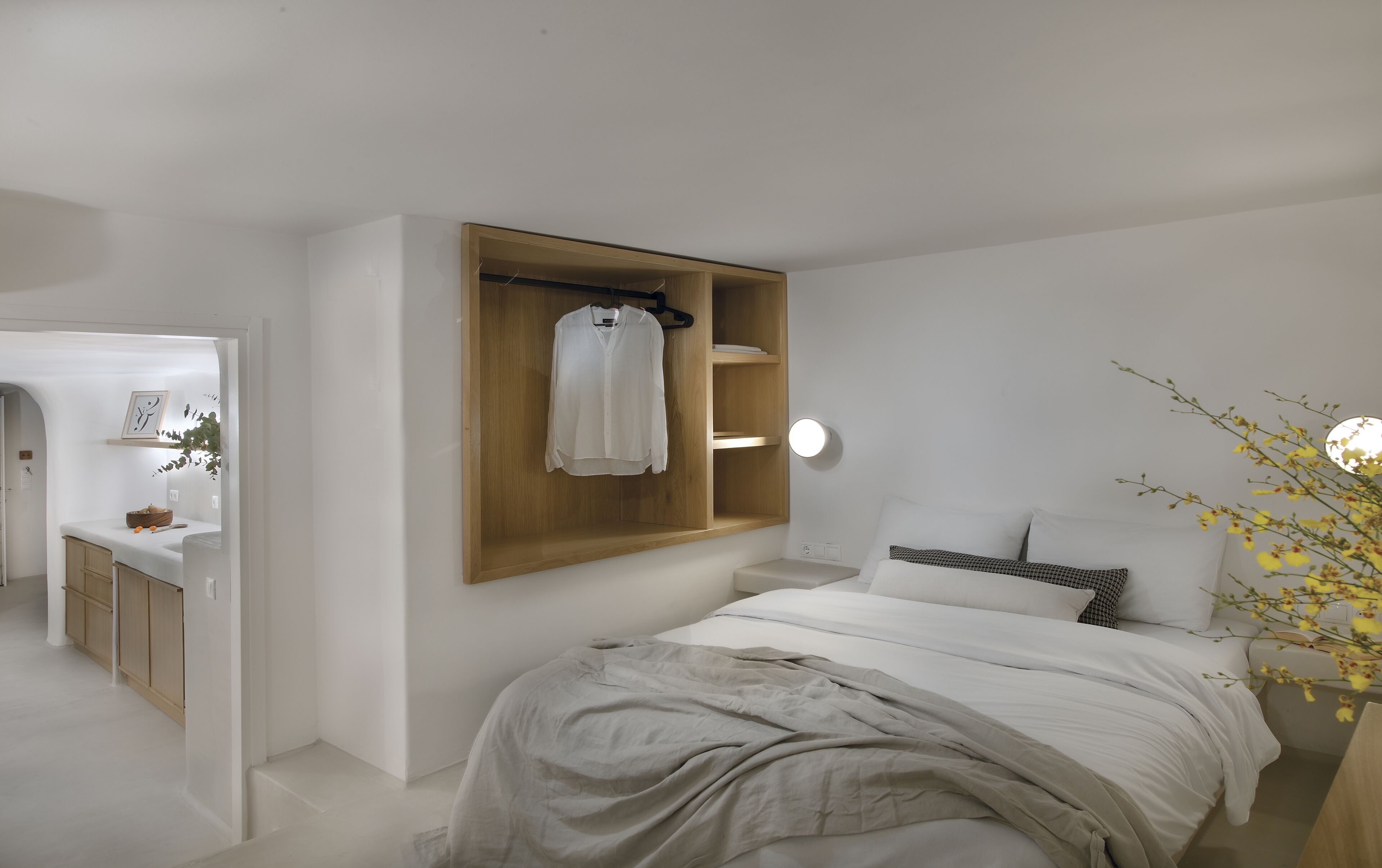 Un dormitorio minimalista con cama, mesita de noche y un armario de madera.