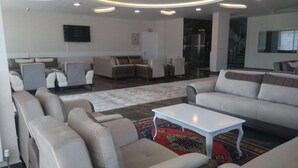 Una sala de estar moderna con sofás, una mesa de centro y un televisor montado en la pared.