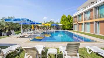 Piscine extérieure, parasols de plage, chaises longues