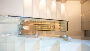 A modern interior with a glass railing, a polished floor, and a central display area. - Dilman Luxury Stay (Bari)