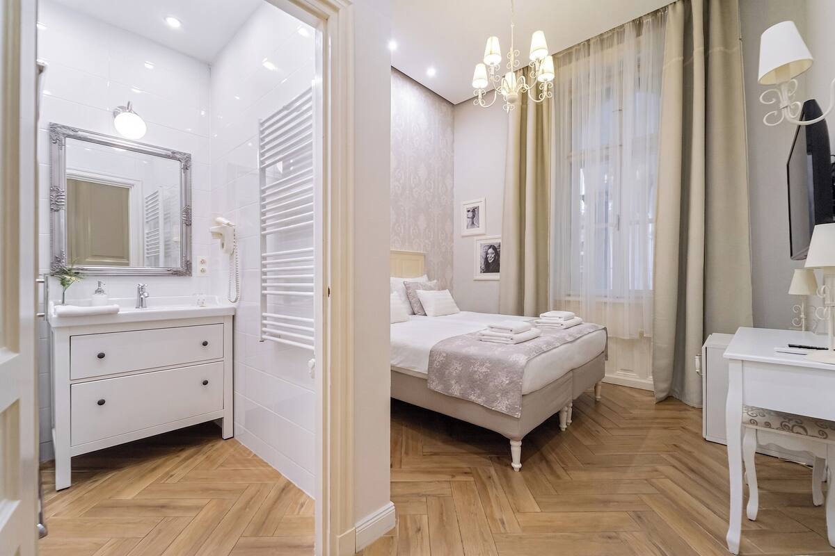 A bedroom with a bed, bedside table, and a mirror.