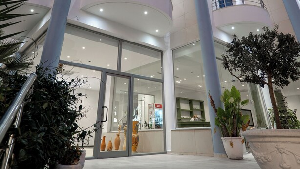 A multi-story hotel with balconies, a reception area, and potted plants. - Arel Hotel (Sarandë)