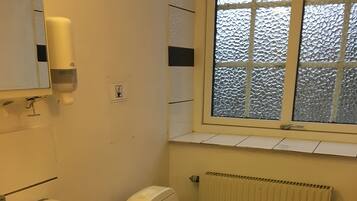 Un baño con lavamanos blanco, inodoro y ventana.