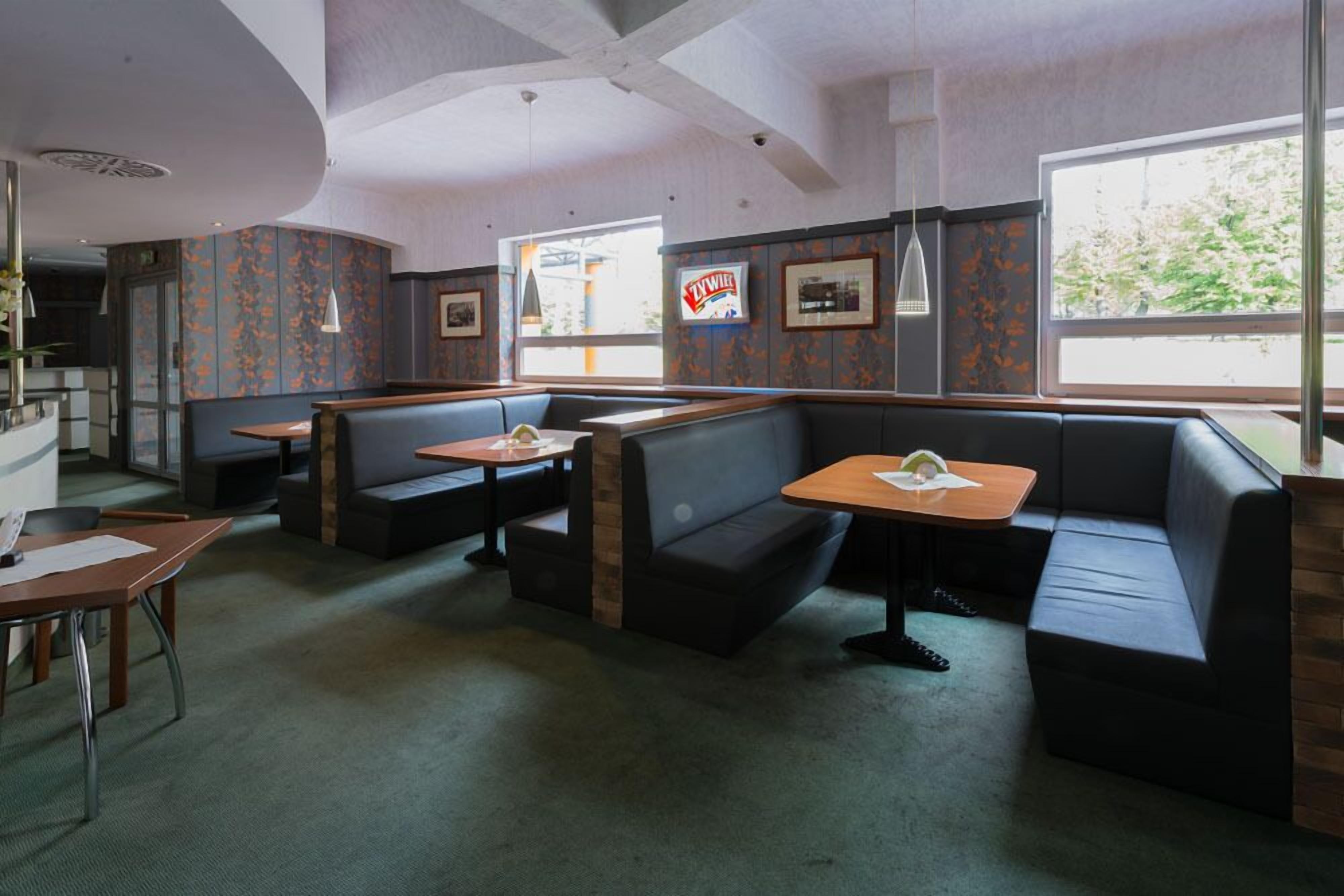 Un ristorante con banconi e tavoli, dotato di un'ampia vetrata e un'insegna con il marchio 'ZYWAR'.