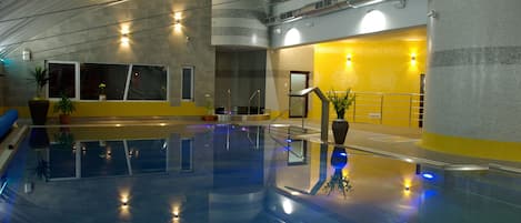 Una piscina techada, sillones reclinables de piscina