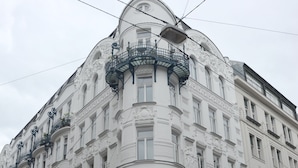 A white building with ornate architectural details, including balconies and a dome. - Soho Apartments - Grand Soho (Vienna)