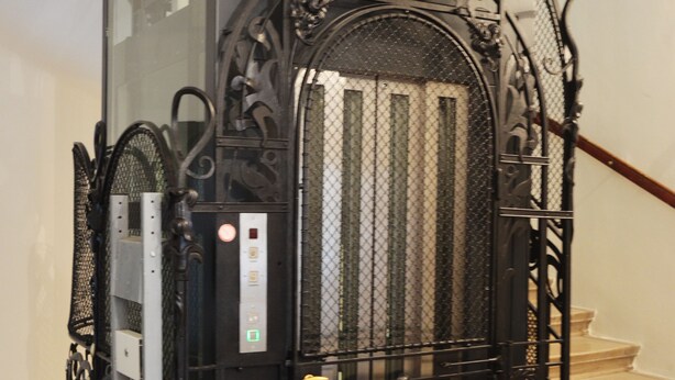 A black elevator with ornate metalwork and a control panel. - Soho Apartments - Grand Soho (Vienna)