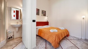 A hotel room with a bed, a bathroom with a sink, and a mirror. - Lucca in Villa San Marco (Lucca)