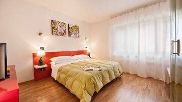 Une chambre d’hôtel moderne équipée d’un lit, de lampes de chevet, d’une télévision et d’œuvres d’art accrochées au mur.