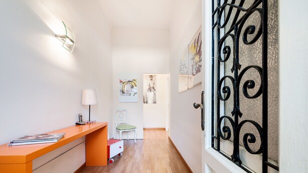 A hallway with a desk, chair, and artwork on the walls. - Lucca in Villa San Marco (Lucca)