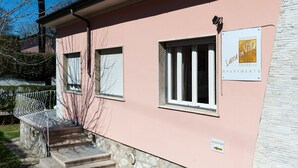 A pink building with a reception sign, a staircase, and a sign for apartments. - Lucca in Villa San Marco (Lucca)