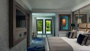 Habitación de hotel con una cama grande, un escritorio y vistas a zonas verdes.