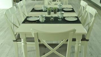 Een eettafel gedekt met borden, glazen en een klein plantje.