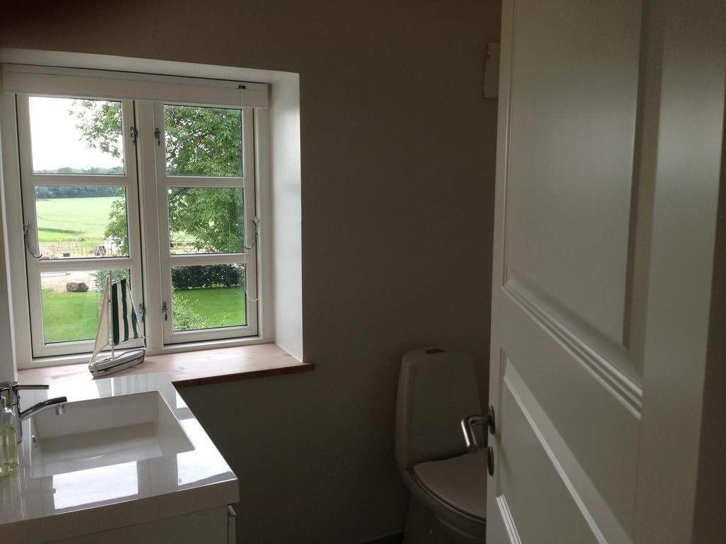 A bathroom with a window, a sink, and a toilet.