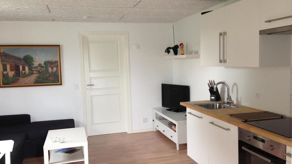 Un espacio habitable compacto con kitchenette, comedor y televisor.
