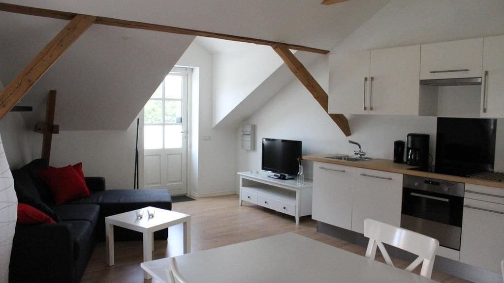 Un apartament modern estil loft amb zona de menjador, cuina i saló.