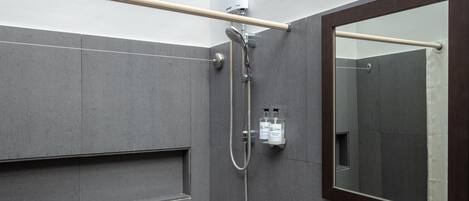 A modern bathroom with a shower, a sink, and a mirror.