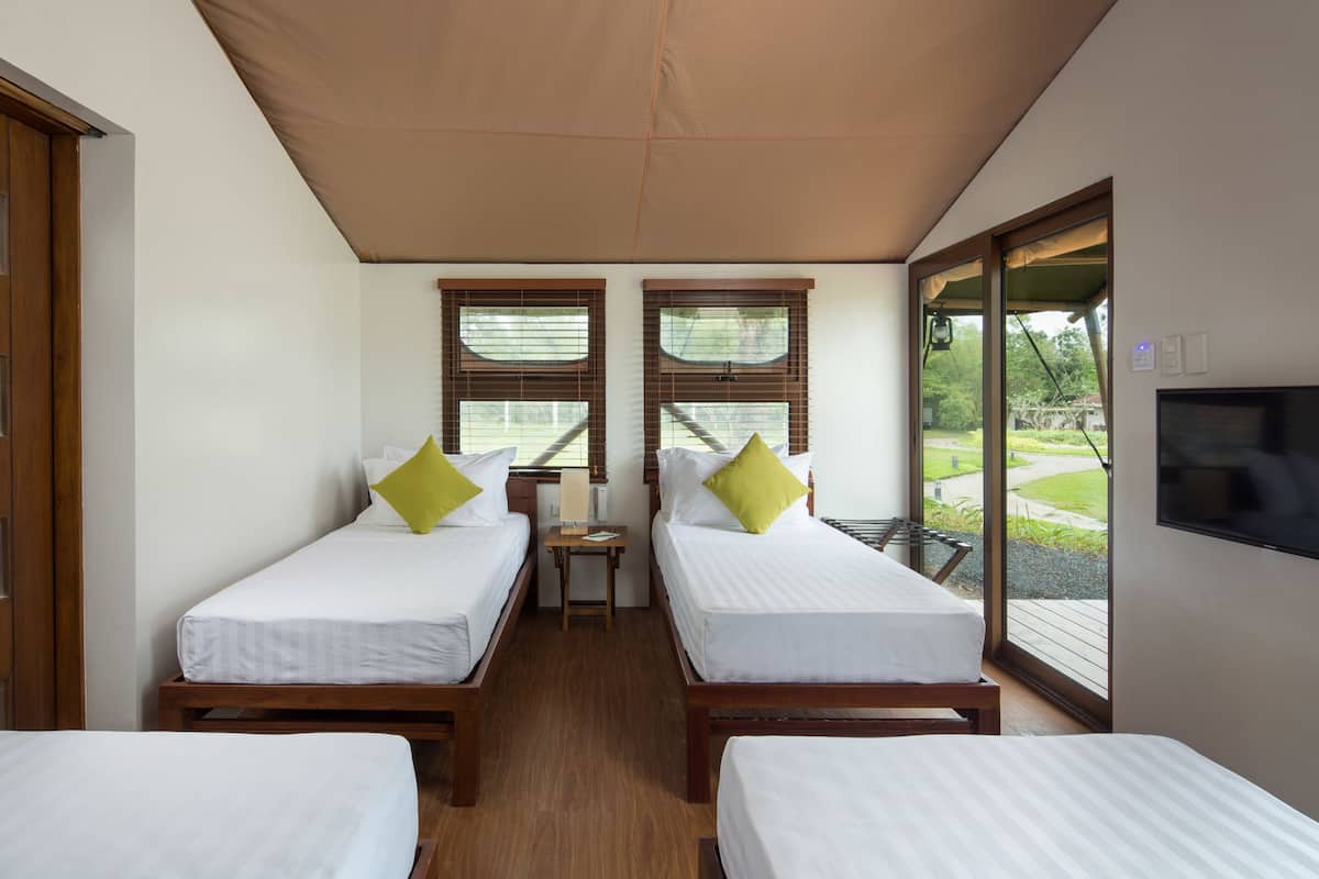 A room with two single beds, a small table, and a TV.