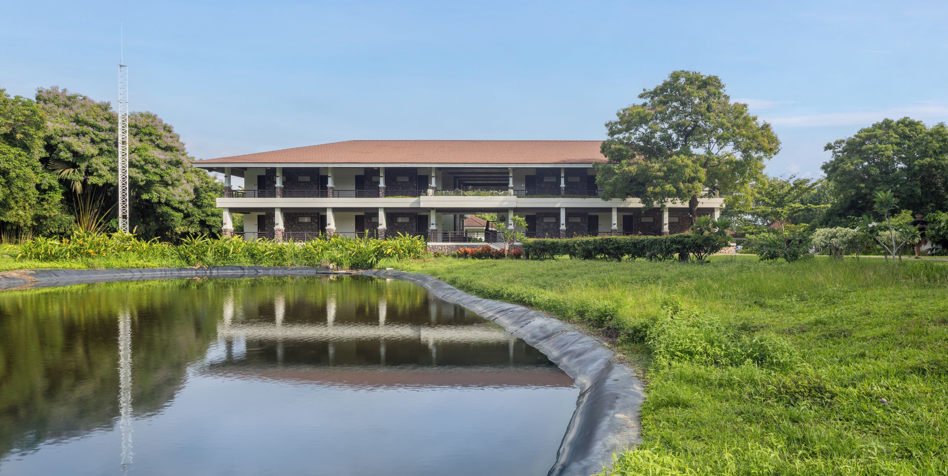 A two-story building with a flat roof and a central courtyard with a water feature.