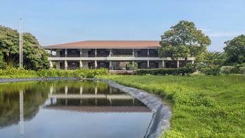 A two-story building with a flat roof and a central courtyard with a water feature.