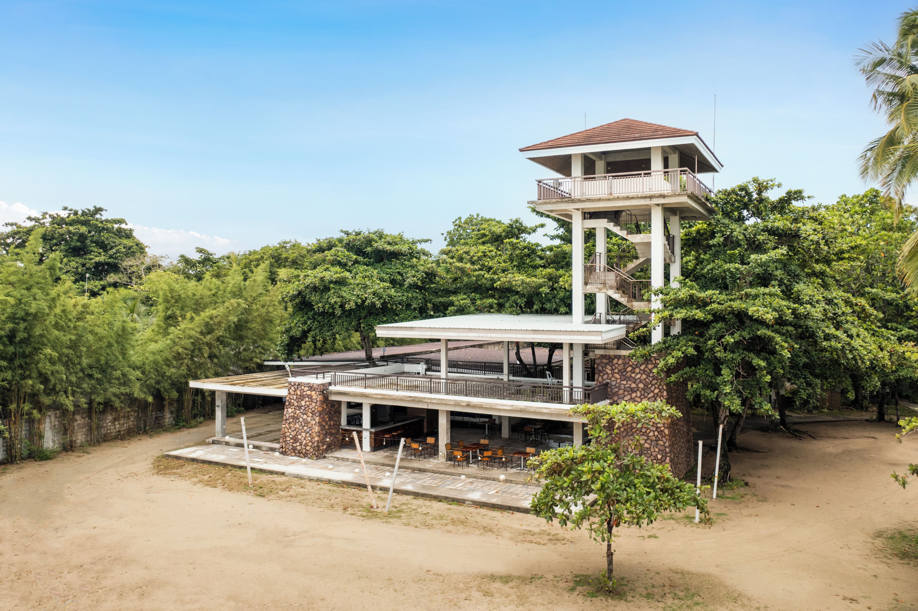 A multi-level building with outdoor seating and a stone facade.