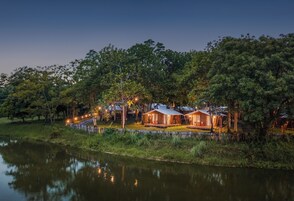 Propiedad frente al lago con varias cabañas, cada una con terraza y rodeadas de árboles.