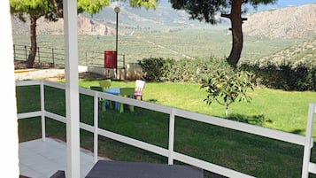 A covered patio with a white railing, a bench, and a table.