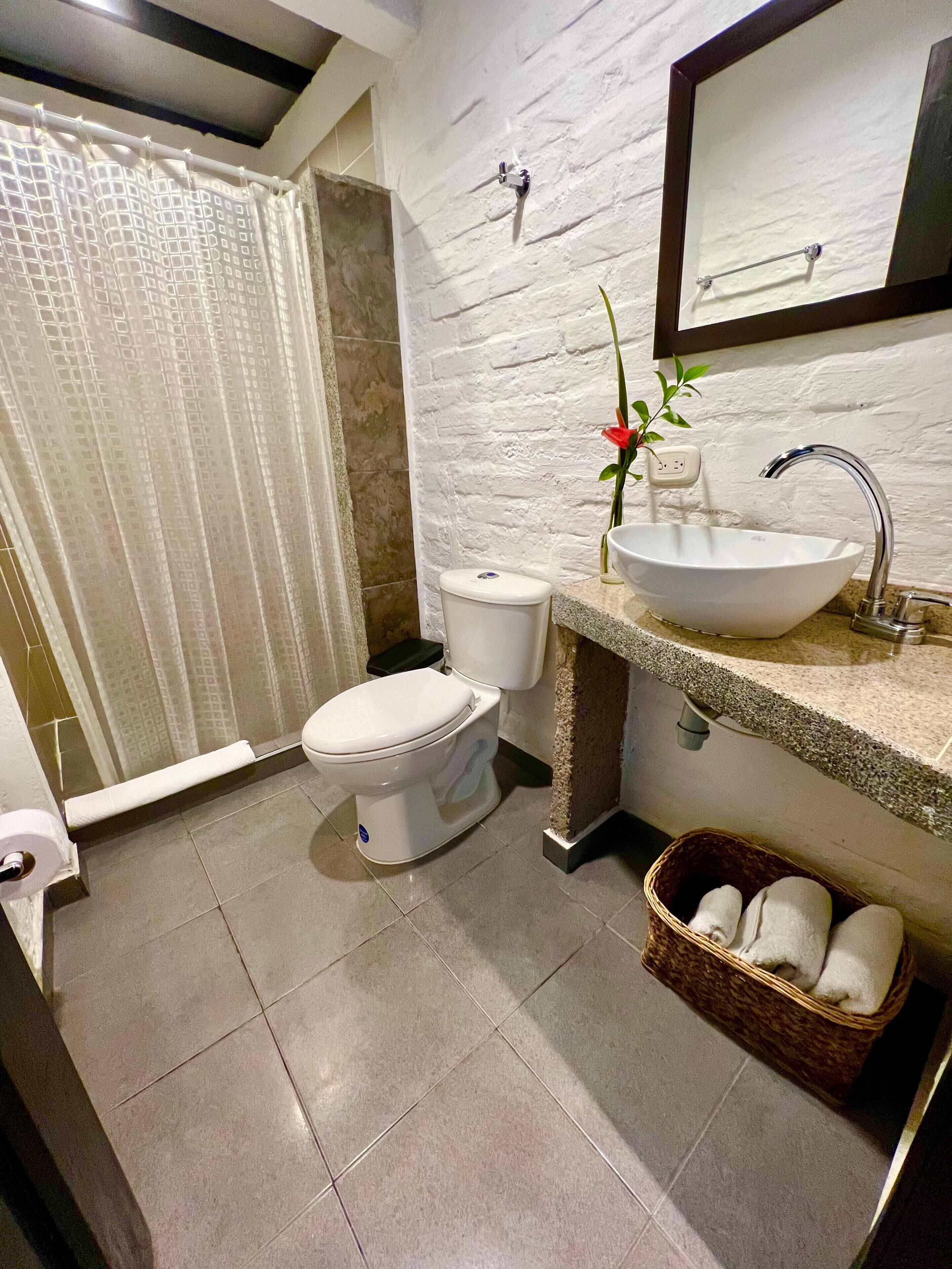 Un baño con inodoro, lavabo y cortina de ducha.