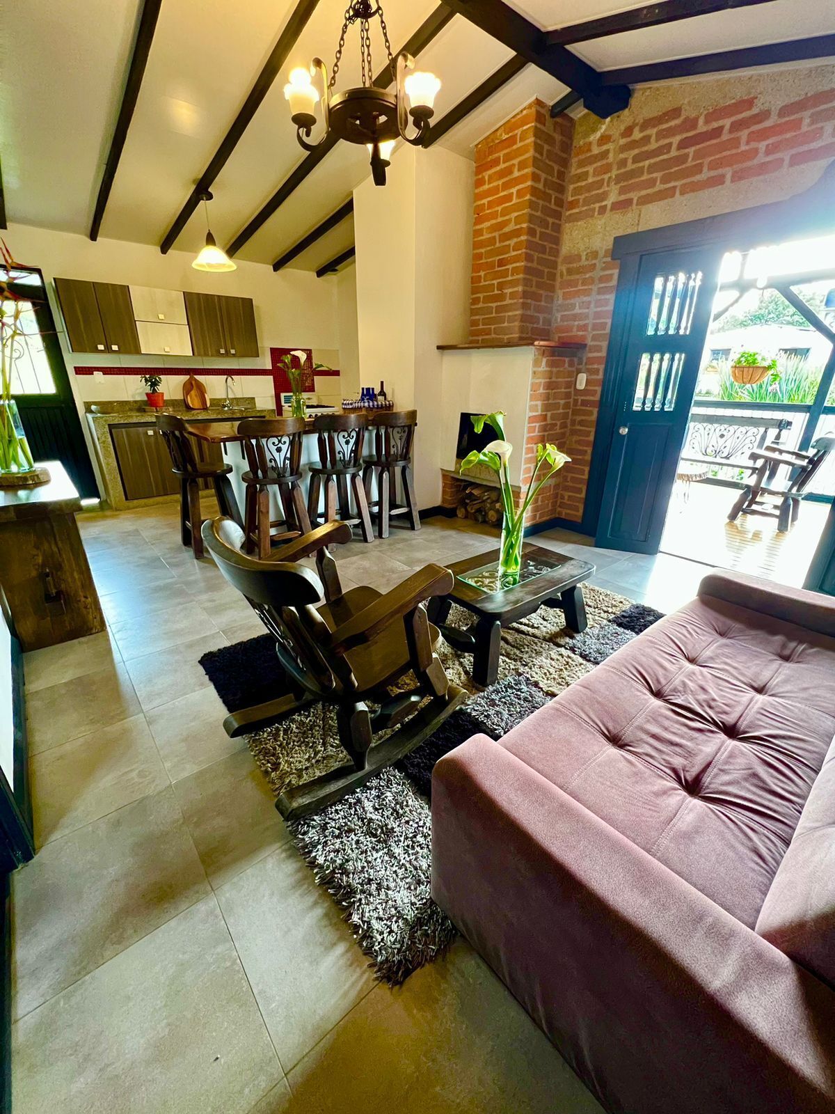 A spacious living area with a fireplace, a dining table with chairs, and a sofa.
