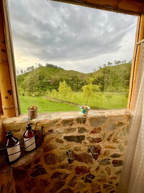 Un muro de piedra con vistas a un paisaje verde y colinas.