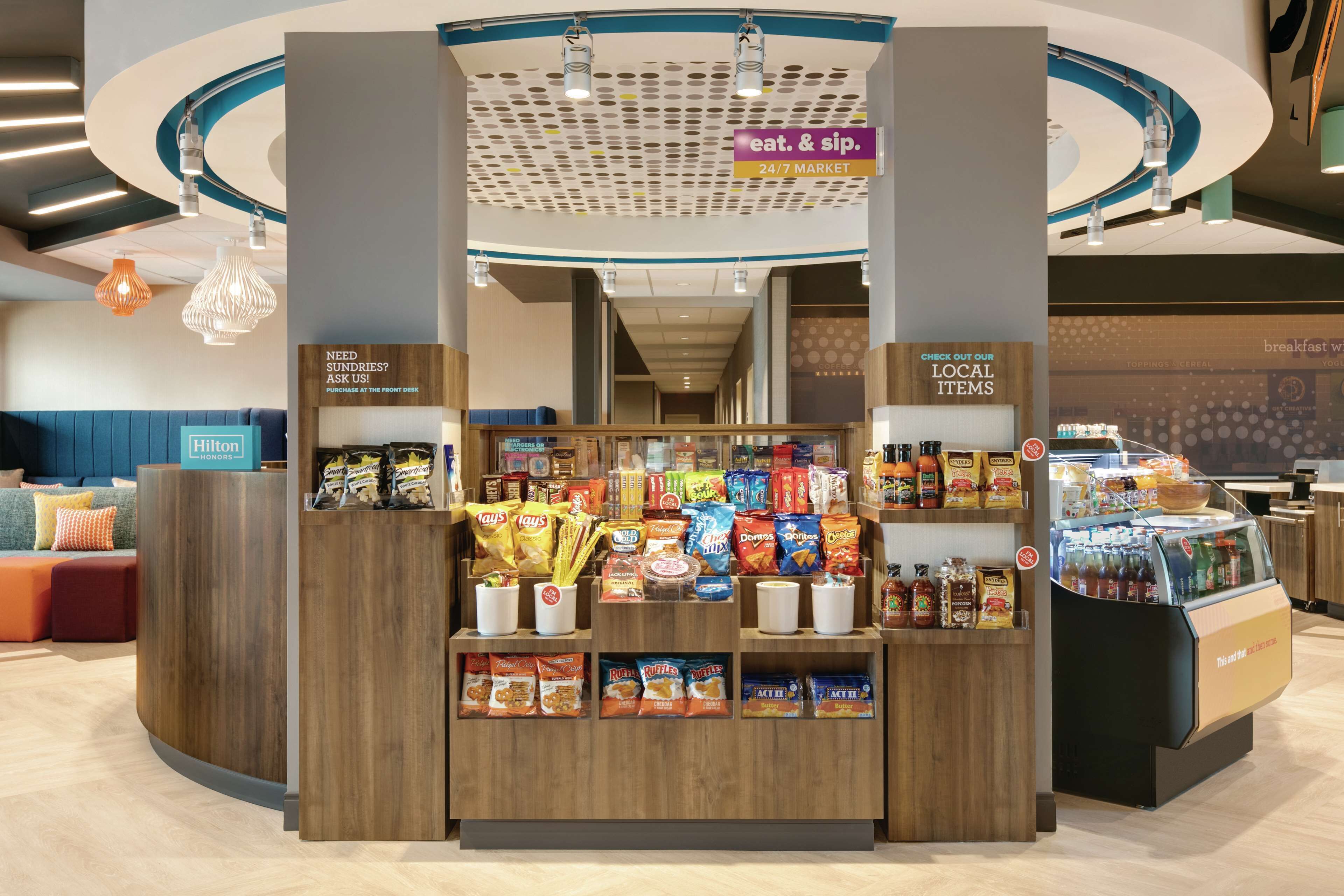 A 24/7 market area with snack and drink options, a seating area, and a sign for the eat & sip section.