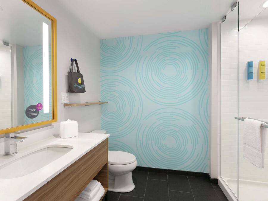 A modern bathroom with a white sink, a toilet, and a shower area.