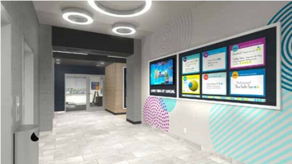 Un pasillo moderno con un panel informativo digital que muestra diversas atracciones y servicios locales.
