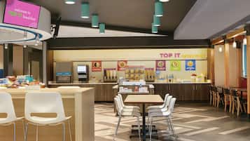 A Top It breakfast area with a counter, seating, and a digital sign.