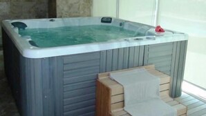 A hot tub with a wooden bench and a towel. - Bay View Grand Marina 2BR (Ixtapa)