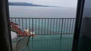 Ein Balkon mit Meerblick, einem Tisch und einem Stuhl.