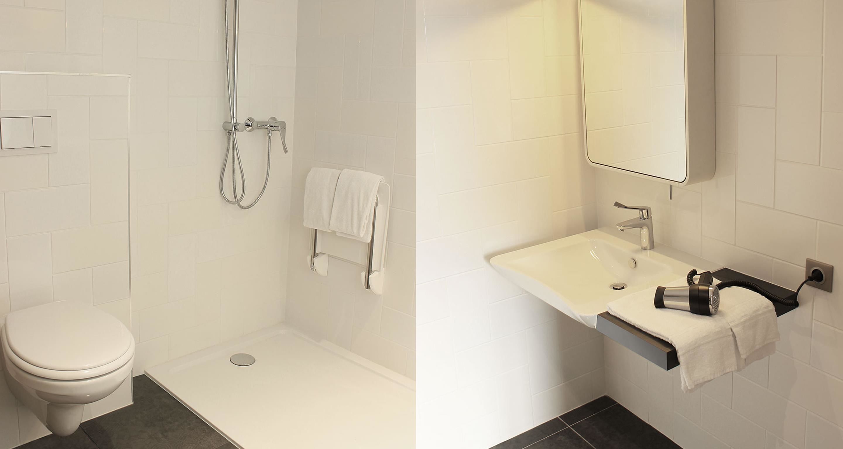 A modern bathroom with a toilet, shower, and sink.
