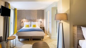 A modern hotel room with a large bed, bedside tables, a flat-screen TV, and a floor lamp. - Best Western La Porte des Châteaux (Meung-sur-Loire)