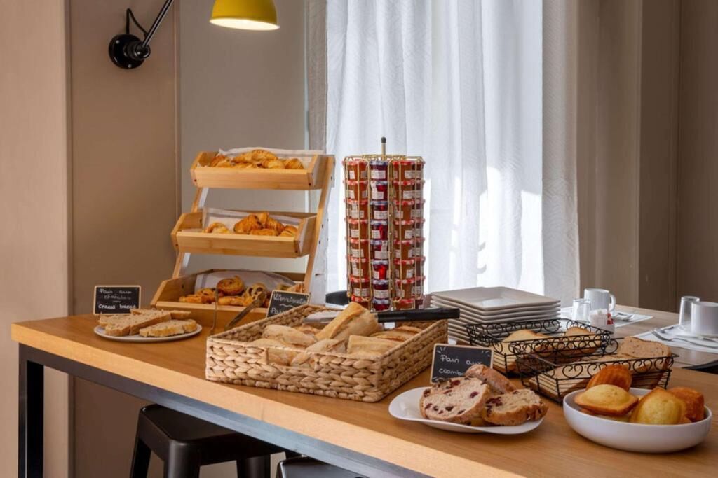 Un bufé de desayuno con diversos pasteles, pan y mermeladas.