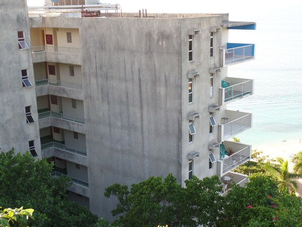 Un edificio a più piani con balconi affacciati su una spiaggia.