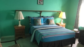 Una camera da letto con un letto, due comodini, una sedia e una lampada.