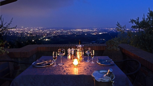 A table set for dining with a city view at dusk. - I Sette Borghi (Massa e Cozzile)