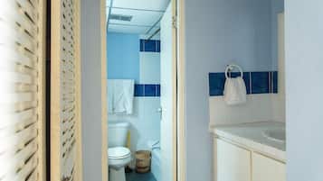 A bathroom with a toilet, a sink, and a blue-tiled wall.