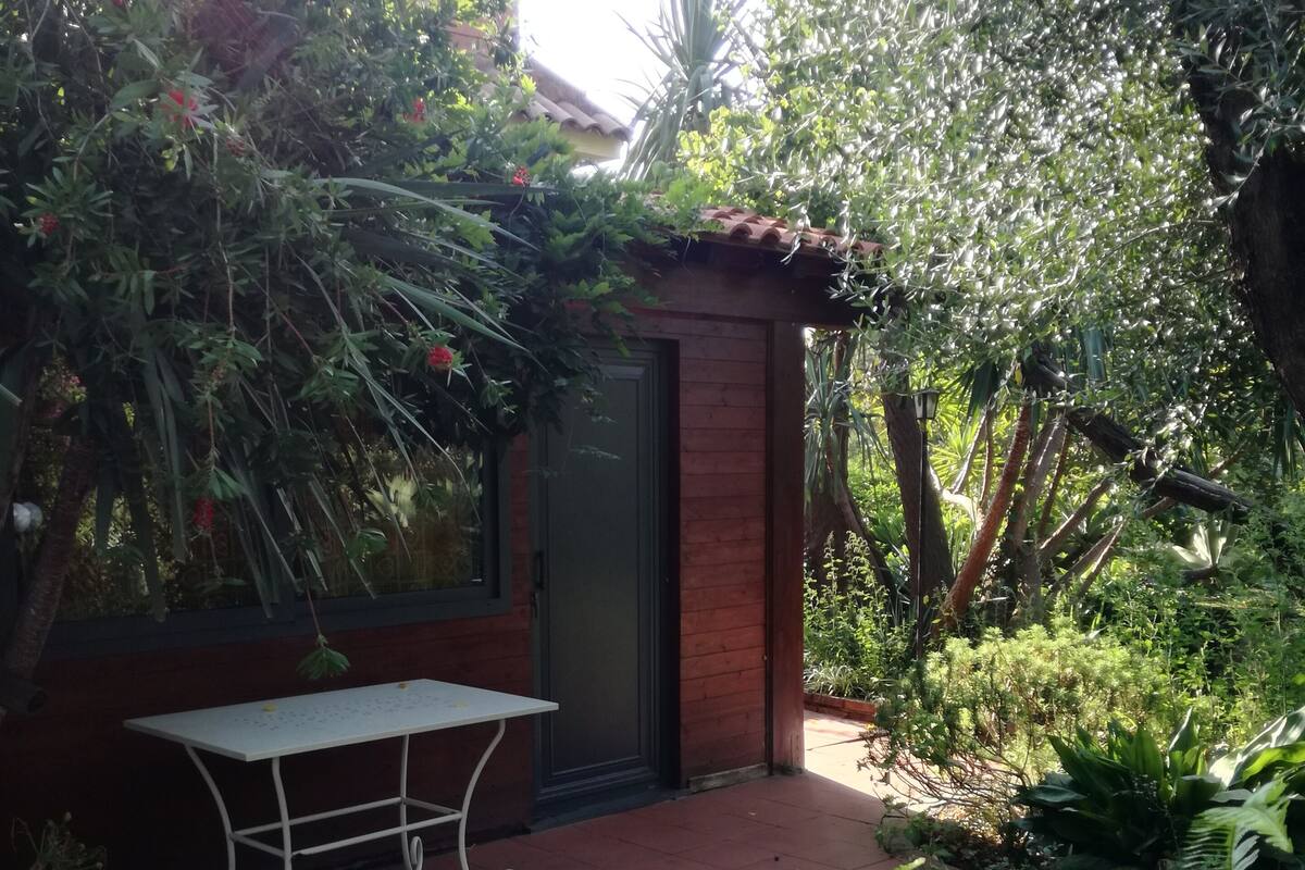 A patio with a checkered floor, a small table, and a door.
