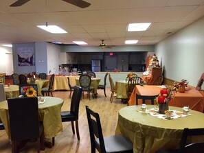 Guests can dine and socialize in this functional dining area, featuring round tables and comfortable seating.