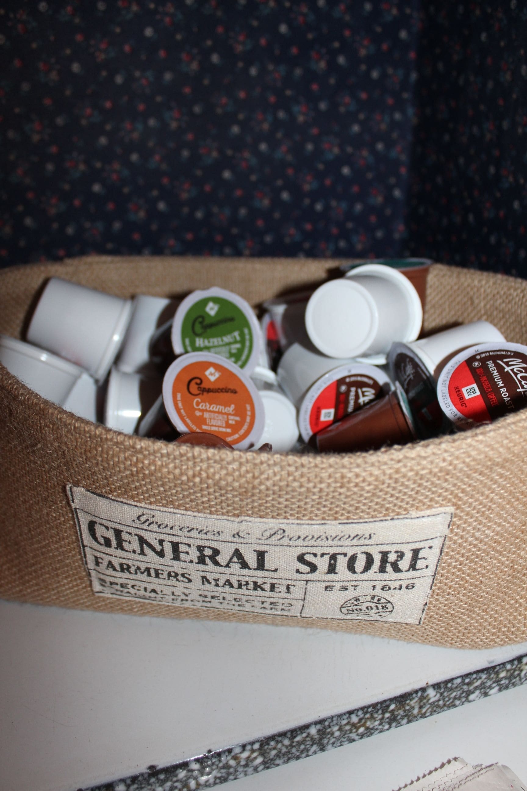 A burlap sack filled with various coffee containers, labeled with different flavors like caramel and hazelnut.