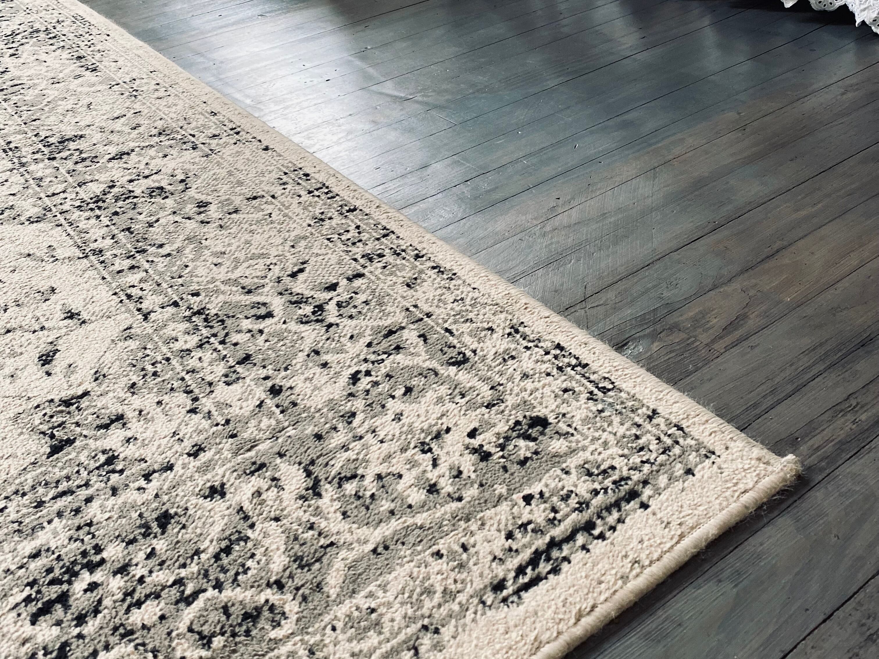 Un tapis à motifs géométriques posé sur un plancher en bois.