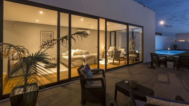 A modern living room with a glass wall, a pool table, and a dining area. - Praia de Santos - Exclusive Guest House (Ponta Delgada)