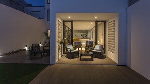 An outdoor patio area with seating and a view into the interior. - Praia de Santos - Exclusive Guest House (Ponta Delgada)