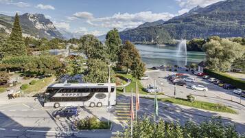 Ein Bus an einer Bushaltestelle vor einer Berglandschaft und einem See.